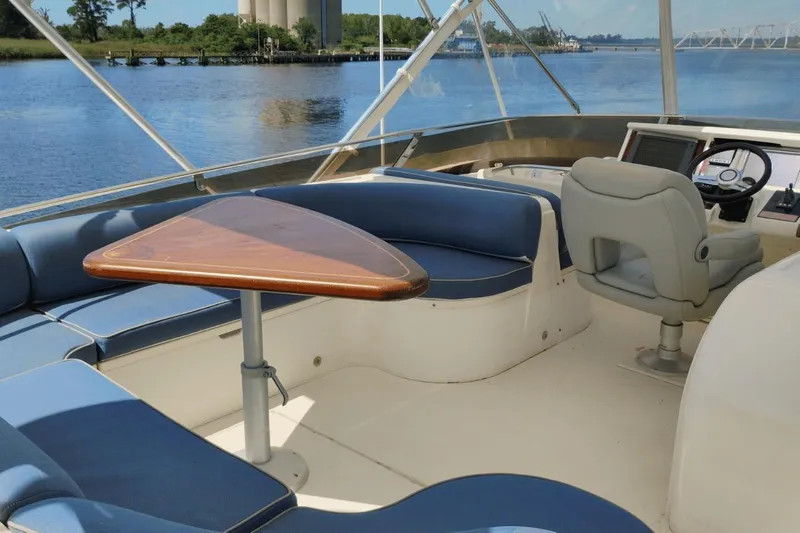  Yacht Photos Pics Luxurious 2001 Viking Princess 72 yacht interior with blue seating and wooden table.