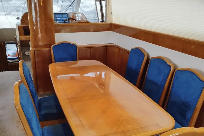  Yacht Photos Pics Luxurious dining area on 2001 Viking Princess 72 yacht with wooden table and blue chairs.