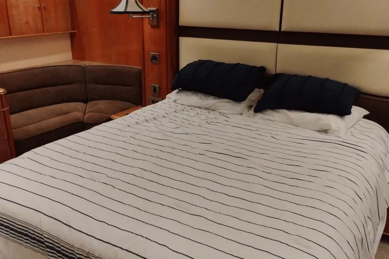  Yacht Photos Pics Luxurious bedroom interior on 2001 Viking Princess 72 yacht, featuring a cozy bed and elegant decor.
