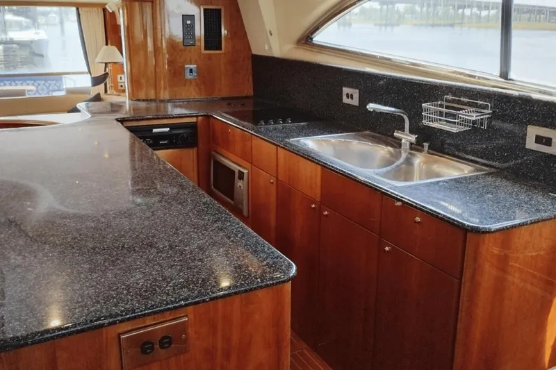  Yacht Photos Pics Luxurious kitchen interior of 2001 Viking Princess 72 yacht with granite countertops and wooden cabinetry.
