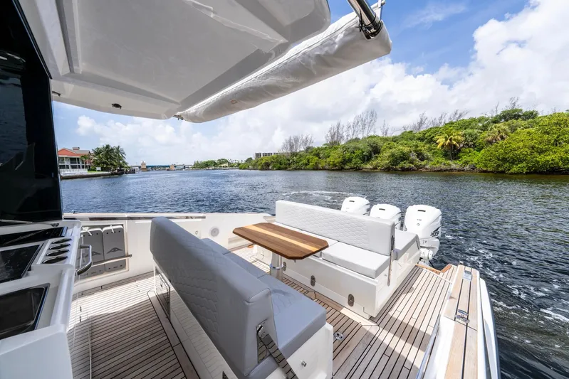 Sea-curitini Yacht Photos Pics 2024 Astondoa 377 yacht deck with seating, table, and scenic waterway view.