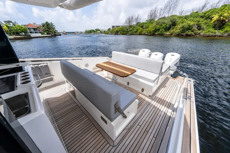 Sea-curitini Yacht Photos Pics Luxurious 2024 Astondoa 377 yacht deck with seating, table, and scenic waterway view.