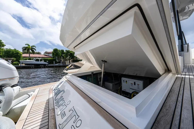 Sea-curitini Yacht Photos Pics 2024 Astondoa 377 yacht with open engine compartment, docked by waterfront homes.