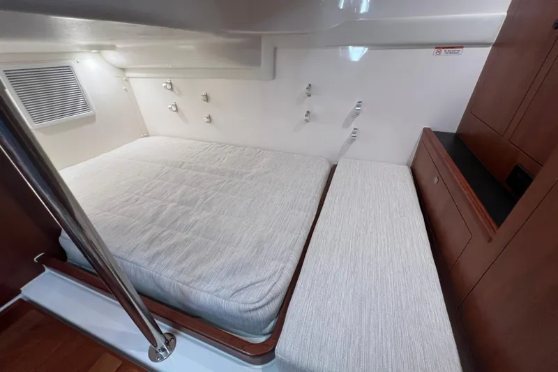 Seaquel Yacht Photos Pics 2026 Pursuit OS 355 Offshore cabin interior with bed and wooden cabinetry.