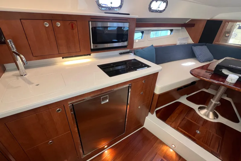 Seaquel Yacht Photos Pics Luxurious interior of 2026 Pursuit OS 355 Offshore yacht with modern kitchen and seating area.