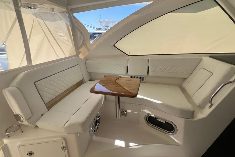Seaquel Yacht Photos Pics Luxurious interior of 2026 Pursuit OS 355 Offshore boat with elegant seating and wooden table.