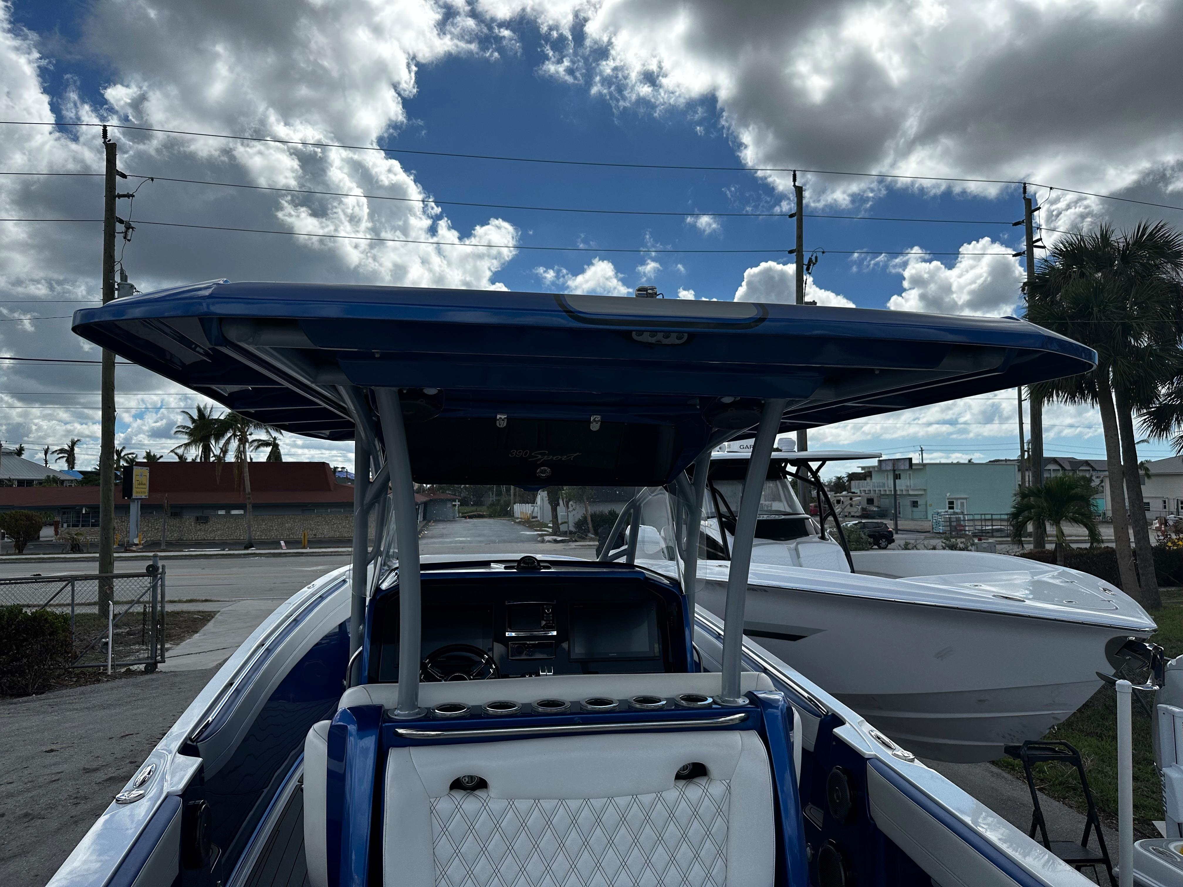 2017 Nor-Tech 390 Center Console boat with blue canopy under cloudy sky.