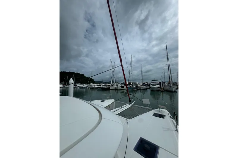Cc Princess Yacht Photos Pics Lagoon 46 catamaran in a marina, cloudy sky, surrounded by sailboats, 2020 model.