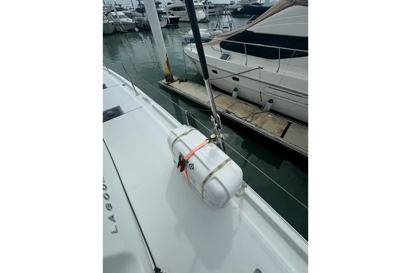 Cc Princess Yacht Photos Pics 2020 Lagoon 46 catamaran docked, featuring a secured white life raft on deck.
