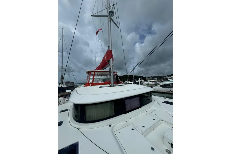 Cc Princess Yacht Photos Pics 2020 Lagoon 46 catamaran with red sail, docked under cloudy skies.