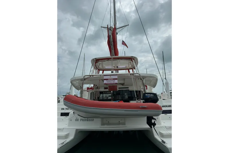 Cc Princess Yacht Photos Pics 2020 Lagoon 46 catamaran with red dinghy, docked under cloudy skies.