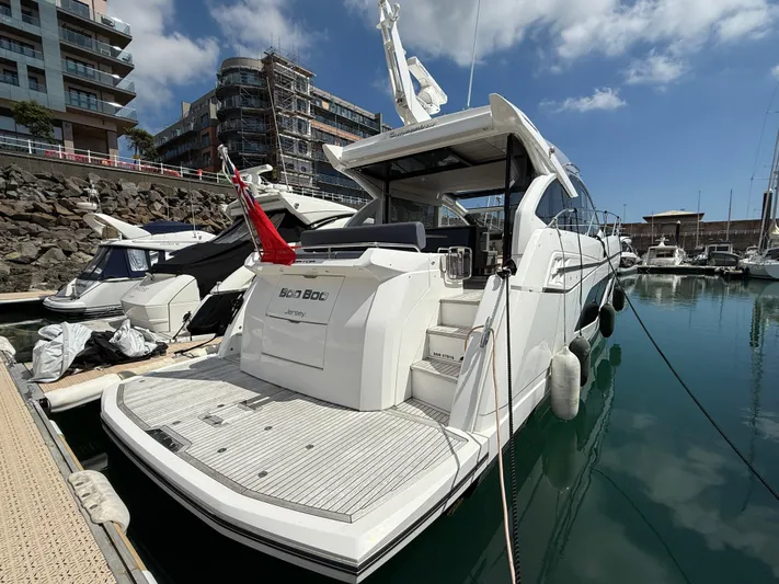 Boo Boo Yacht Photos Pics 2020 Sunseeker Predator 50 yacht docked in marina, surrounded by modern buildings.