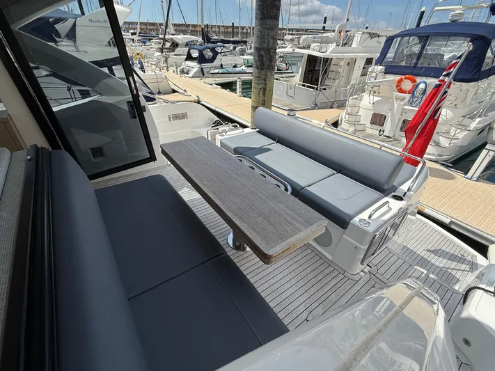 Boo Boo Yacht Photos Pics Sunseeker Predator 50 yacht deck with seating and table, docked at marina, 2020 model.