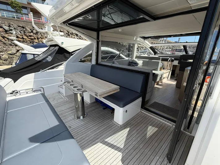 Boo Boo Yacht Photos Pics 2020 Sunseeker Predator 50 yacht interior with seating and table, docked at marina.