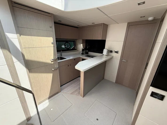 Boo Boo Yacht Photos Pics Modern kitchen interior of 2020 Sunseeker Predator 50 yacht, featuring sleek cabinetry and appliances.