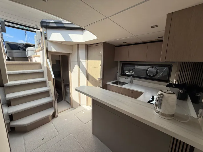 Boo Boo Yacht Photos Pics Luxurious interior of 2020 Sunseeker Predator 50 yacht with modern kitchen and staircase.