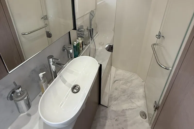 Boo Boo Yacht Photos Pics Luxurious bathroom in 2020 Sunseeker Predator 50 yacht, featuring modern sink and shower.