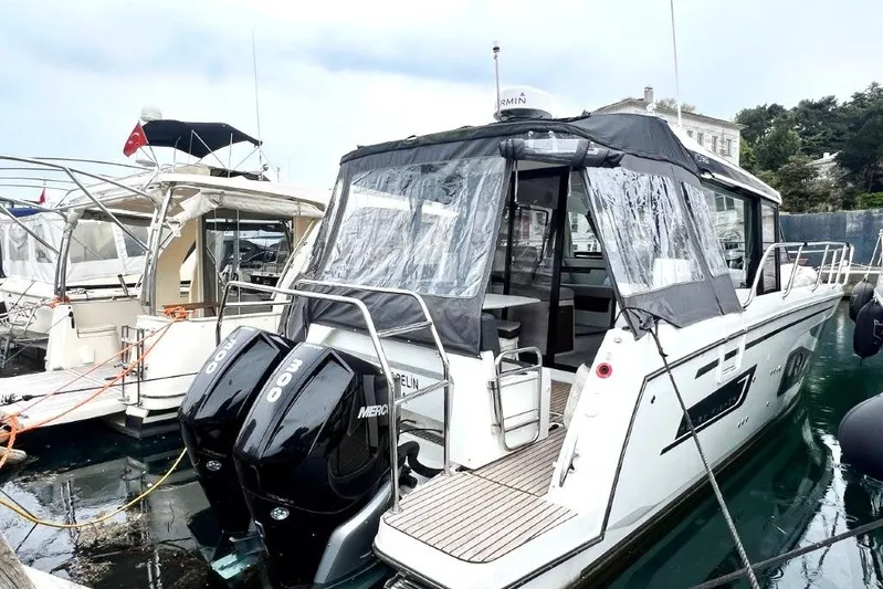  Yacht Photos Pics 2025 Jeanneau Merry Fisher 1095 boat docked with twin Mercury engines, covered seating area.