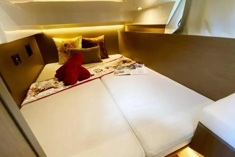  Yacht Photos Pics 2025 Jeanneau Merry Fisher 1095 cabin interior with cozy bedding and decorative pillows.