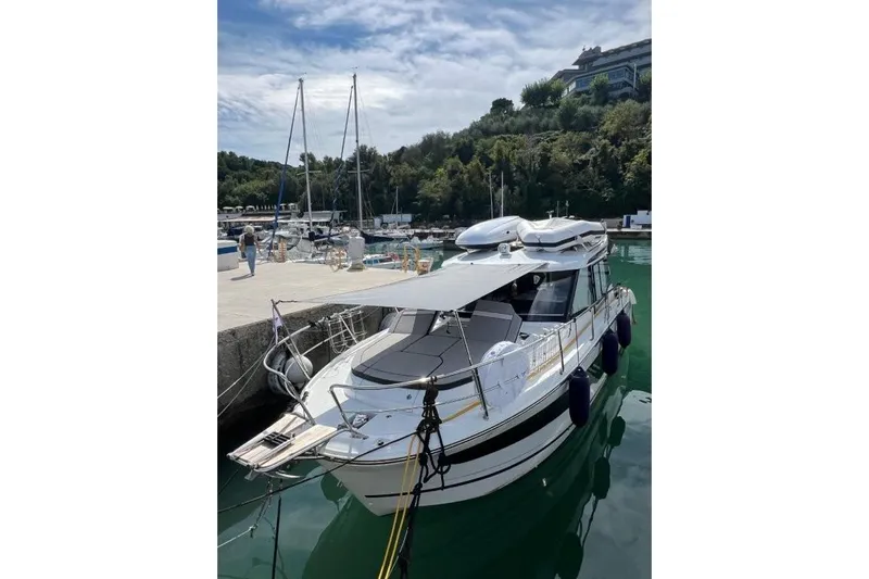  Yacht Photos Pics 2025 Jeanneau Merry Fisher 1095 docked in a scenic marina setting.