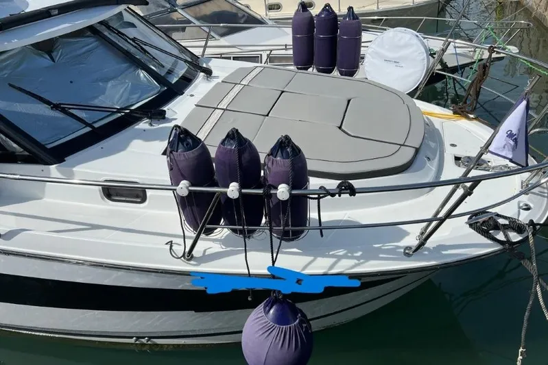  Yacht Photos Pics 2025 Jeanneau Merry Fisher 1095 boat with fenders and sunbathing area, docked in marina.