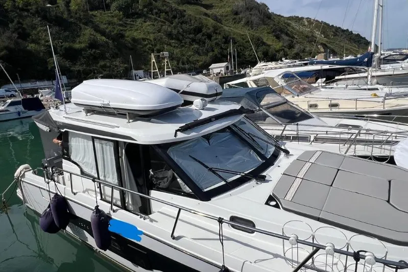  Yacht Photos Pics 2025 Jeanneau Merry Fisher 1095 docked in a marina, surrounded by other boats.