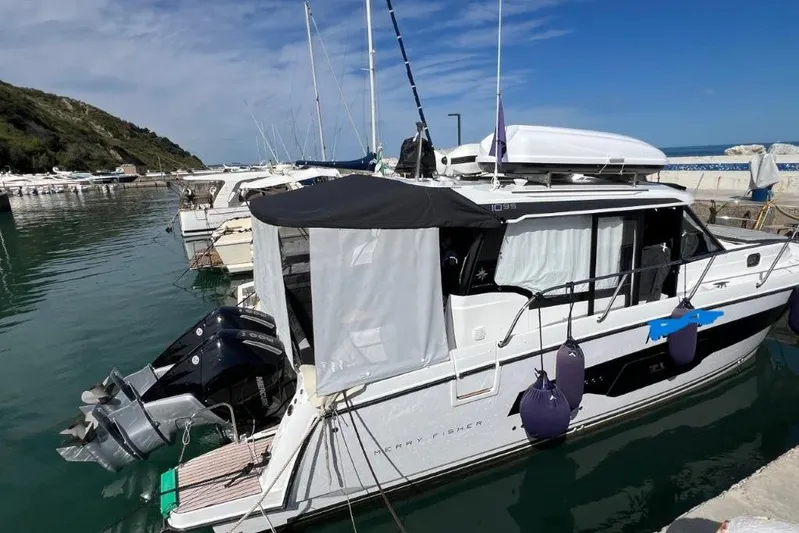  Yacht Photos Pics 2025 Jeanneau Merry Fisher 1095 docked in a serene marina setting.