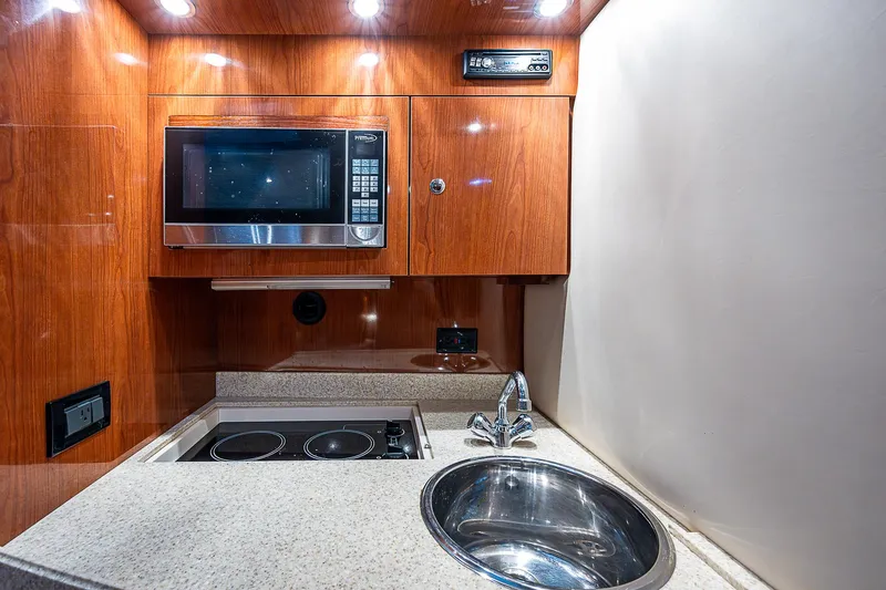  Yacht Photos Pics 2008 Regal Commodore 3760 IB yacht kitchen with microwave, stove, and sink.