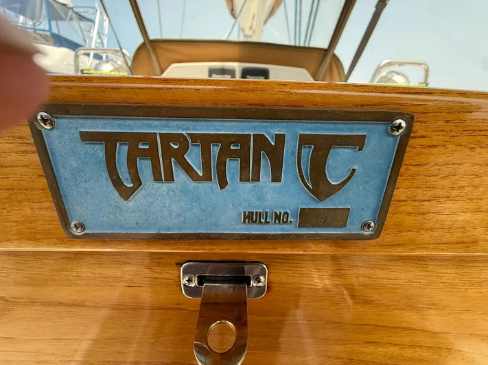 Chapter 9 Yacht Photos Pics Tartan 4000 sailboat nameplate, 2012 model, featuring hull number on wooden surface.