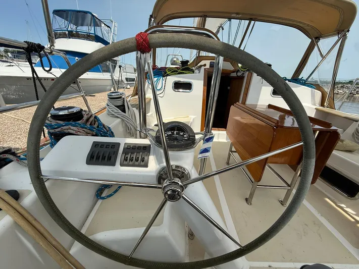 Chapter 9 Yacht Photos Pics Steering wheel of a 2012 Tartan 4000 sailboat, docked with visible cockpit controls.
