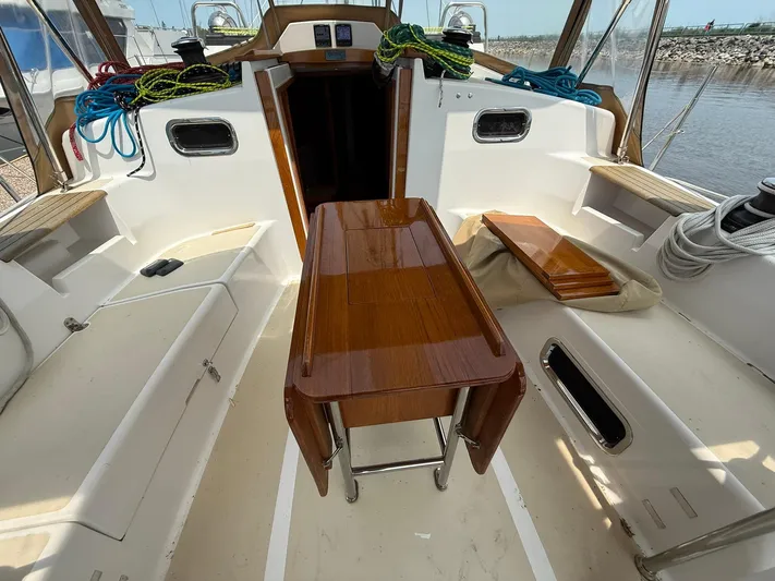 Chapter 9 Yacht Photos Pics 2012 Tartan 4000 yacht cockpit with wooden table, ropes, and seating.