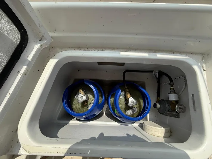 Chapter 9 Yacht Photos Pics Propane storage compartment on 2012 Tartan 4000 boat with two blue-capped tanks.