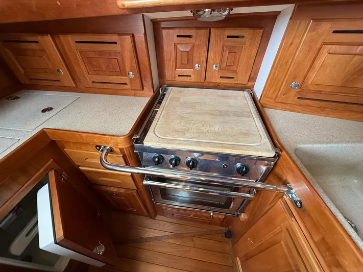 Chapter 9 Yacht Photos Pics Wooden kitchen interior of 2012 Tartan 4000 yacht with stove and cabinetry.