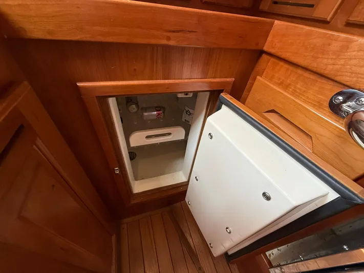Chapter 9 Yacht Photos Pics Wooden interior of a 2012 Tartan 4000 yacht, featuring a small storage compartment.