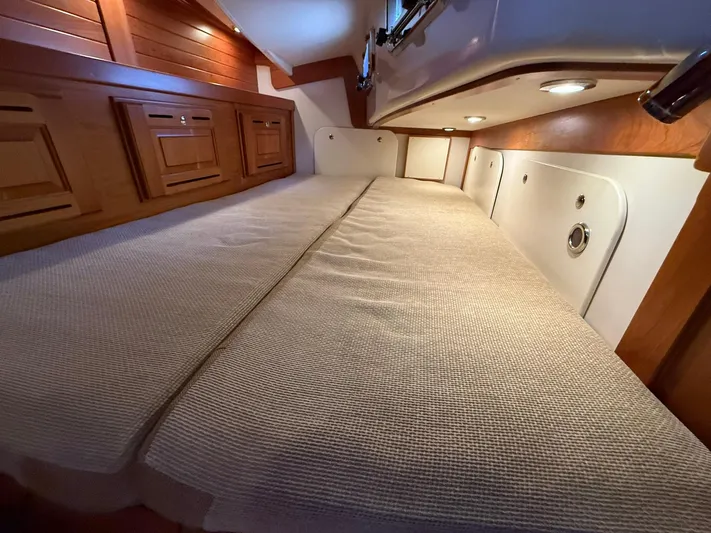 Chapter 9 Yacht Photos Pics Luxurious cabin interior of 2012 Tartan 4000 yacht with cozy bedding and wooden accents.