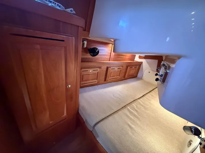 Chapter 9 Yacht Photos Pics Cozy cabin interior of 2012 Tartan 4000 yacht with wooden cabinetry and comfortable bedding.
