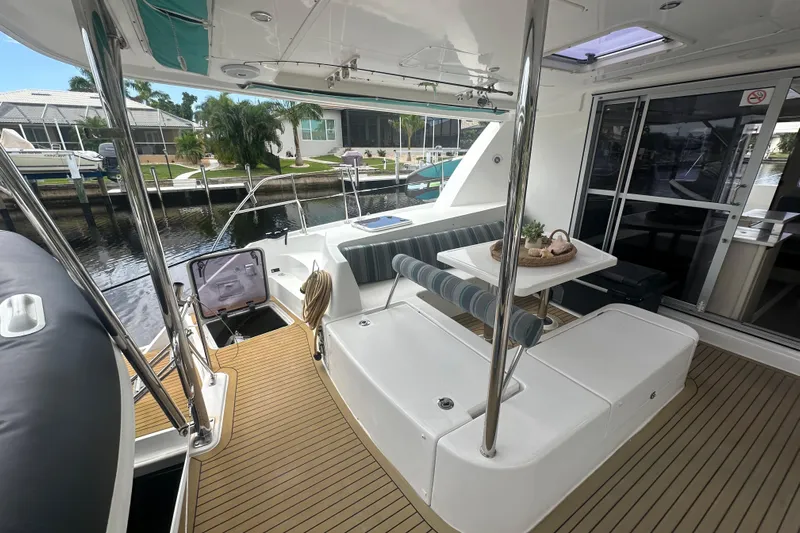 Ohana Yacht Photos Pics 2016 Leopard 44 yacht interior with seating area and table, docked at marina.