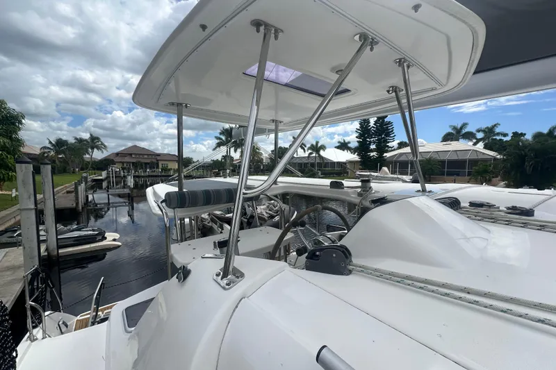 Ohana Yacht Photos Pics 2016 Leopard 44 catamaran docked, showcasing helm and canopy under a partly cloudy sky.