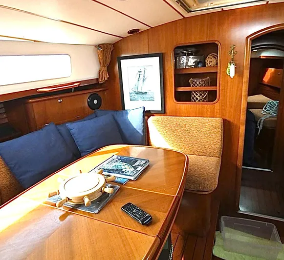 Princessa Yacht Photos Pics Interior of 2000 Beneteau 44 Center Cockpit with wooden furnishings and cozy seating area.