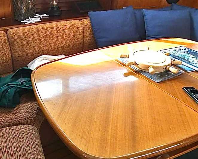 Princessa Yacht Photos Pics Interior of 2000 Beneteau 44 Center Cockpit with wooden table and cushioned seating.