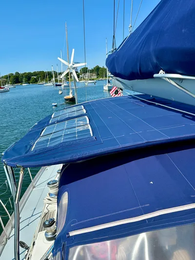 Après Yacht Photos Pics Beneteau 57 sailboat, 2010 model, with solar panels and wind turbine, docked in a serene marina.