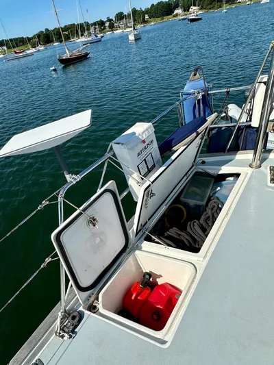 Après Yacht Photos Pics Beneteau 57 sailboat deck with open storage compartments, docked in a scenic marina.