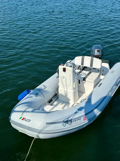 Après Yacht Photos Pics Small inflatable boat on water, featuring a motor and seating, near a Beneteau 57 yacht.