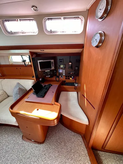 Après Yacht Photos Pics Interior of 2010 Beneteau 57 yacht with navigation station and seating area.