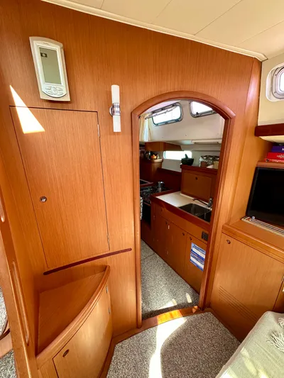Après Yacht Photos Pics Interior of 2010 Beneteau 57 yacht, featuring wooden cabinetry and compact kitchen area.