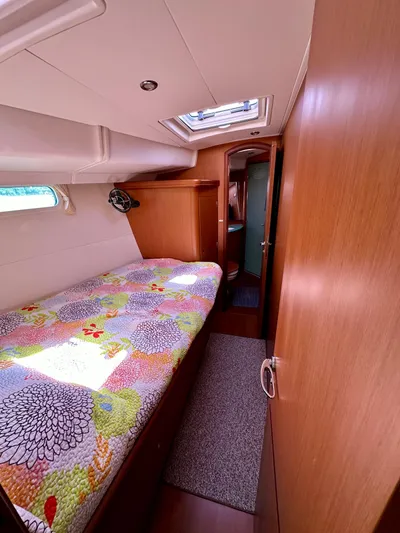 Après Yacht Photos Pics Cozy cabin interior of 2010 Beneteau 57 yacht with colorful bedding and natural light.