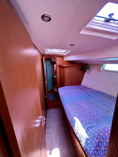 Après Yacht Photos Pics 2010 Beneteau 57 yacht cabin with cozy bed, wooden interior, and natural light.