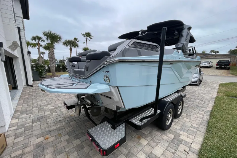 Motivated Yacht Photos Pics 2025 Nautique Super Air Nautique G23 Paragon boat on trailer, parked on driveway.