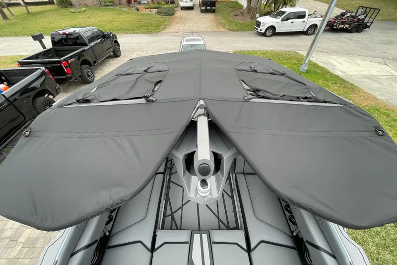 Motivated Yacht Photos Pics 2025 Nautique Super Air Nautique G23 Paragon with black cover, parked outdoors.