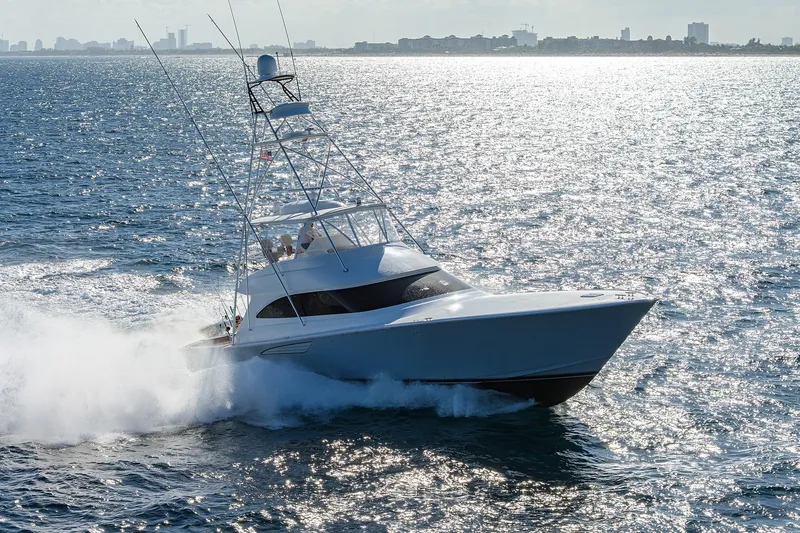 Yacht Photos Pics 2015 Viking 62 Convertible yacht cruising on open water, city skyline in background.